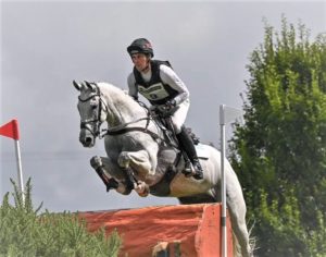 Joseph Murphy jumping a fence on beautiful grey horse Calmaro